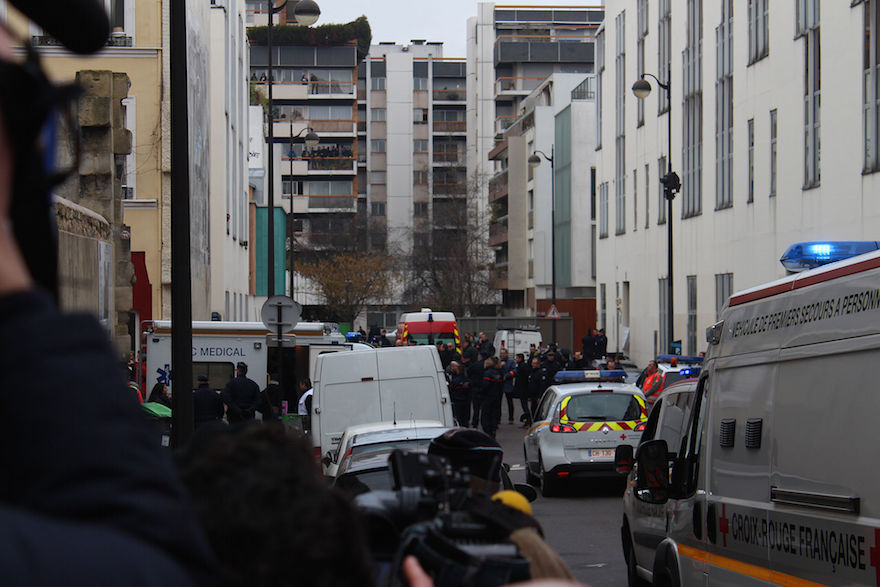 Journalists, policemen, and emergency services in the street of the shooting, a few hours after the January 2015 attack. Credit: Wikimedia Commons