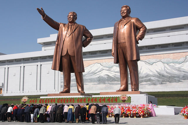 North Koreans bowing to the statues of Kim Il-sung and Kim Jong-il | Credit: Wikimedia Commons